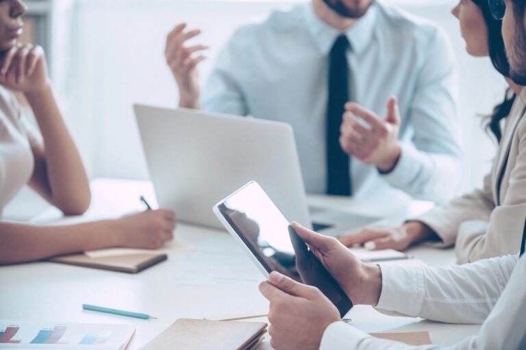 Business professionals discussing bookkeeping services with a laptop and tablet